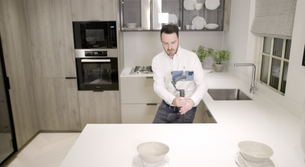 Filming techniques - First Viewings A image of a real estate agent filming a real estate video on a gimbal in a kitchen.