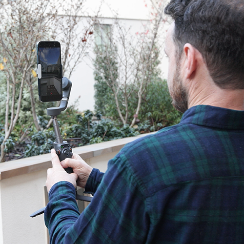 set-the-scene - First Viewings An image of a real estate agent filming a property video outside a development.